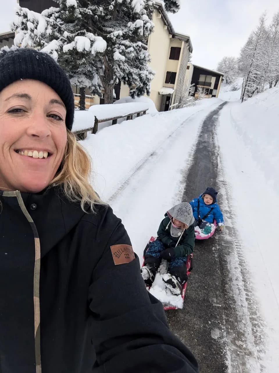 Anne tire les enfants en luge dans la station enneigée